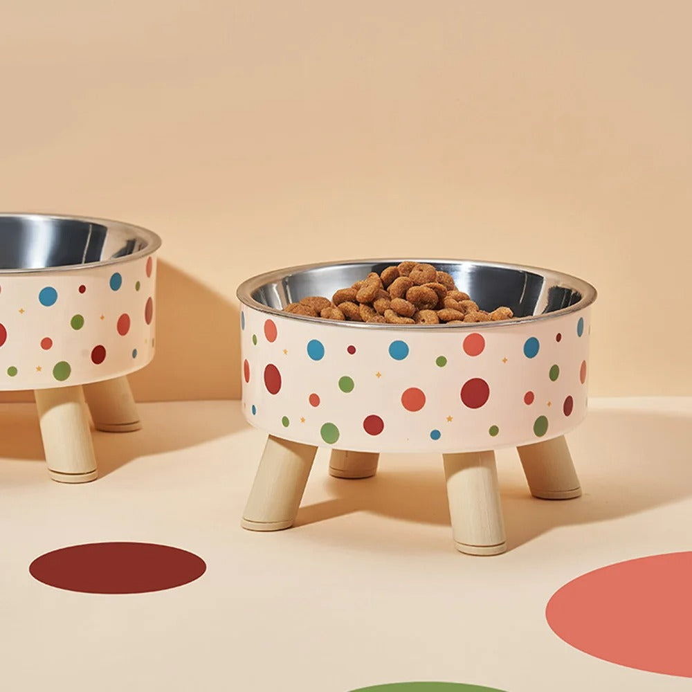 Polka dot pet bowls with wooden legs on a beige background