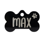 Black bone-shaped pet tag with 'max' and a paw print on a white background