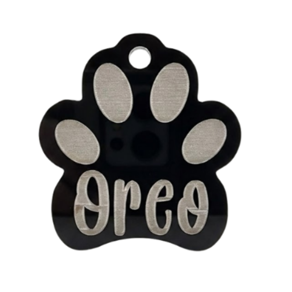 Paw-shaped pet tag with 'Oreo' engraved on a white background
