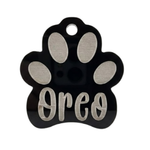 Paw-shaped pet tag with 'Oreo' engraved on a white background