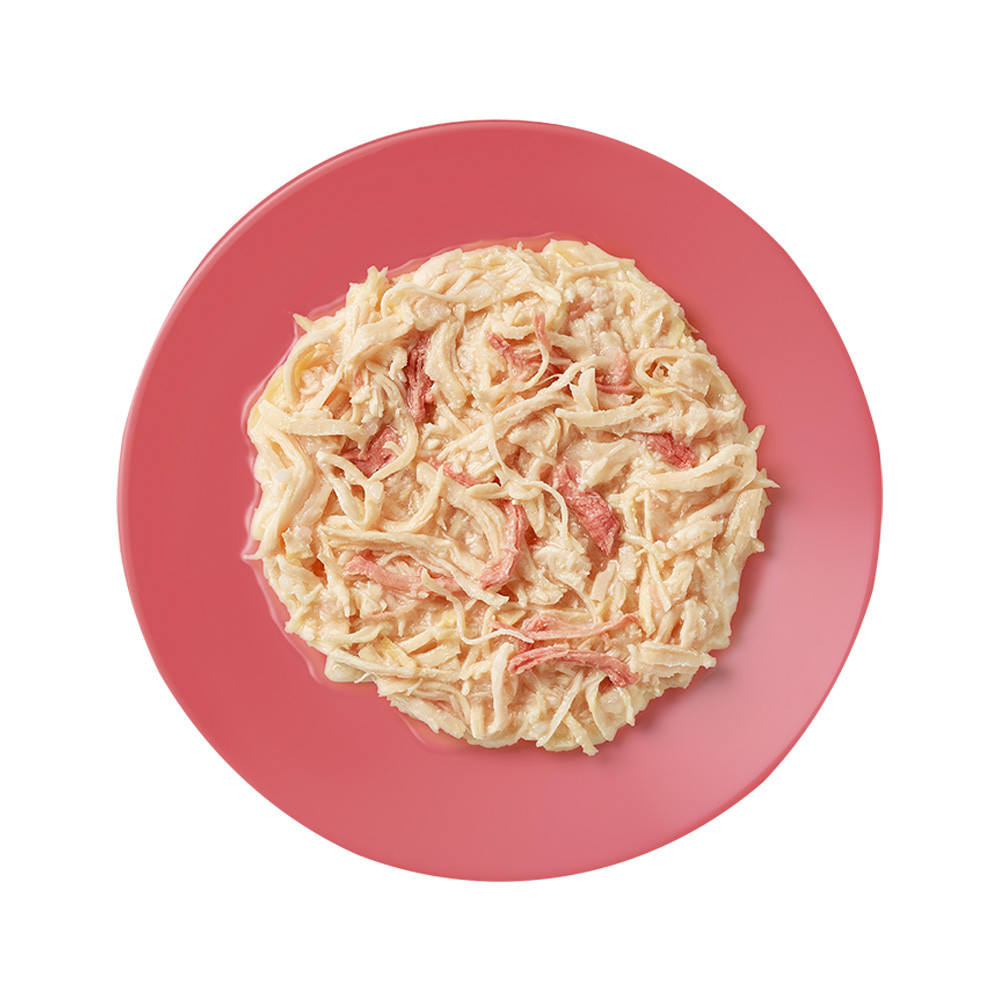 Pink plate with creamy pasta dish on a white background