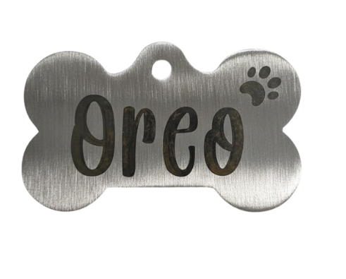 Metallic bone-shaped pet tag with 'Oreo' engraved on a white background
