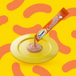 Dreamy creamy chocolate bar being unwrapped on a yellow plate with a colorful abstract pattern in the background.