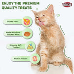 Cat enjoying premium quality treats with Trixie branding and feature text.