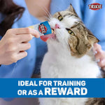Cat being given a Trixie treat by a person, with text about training or rewards.