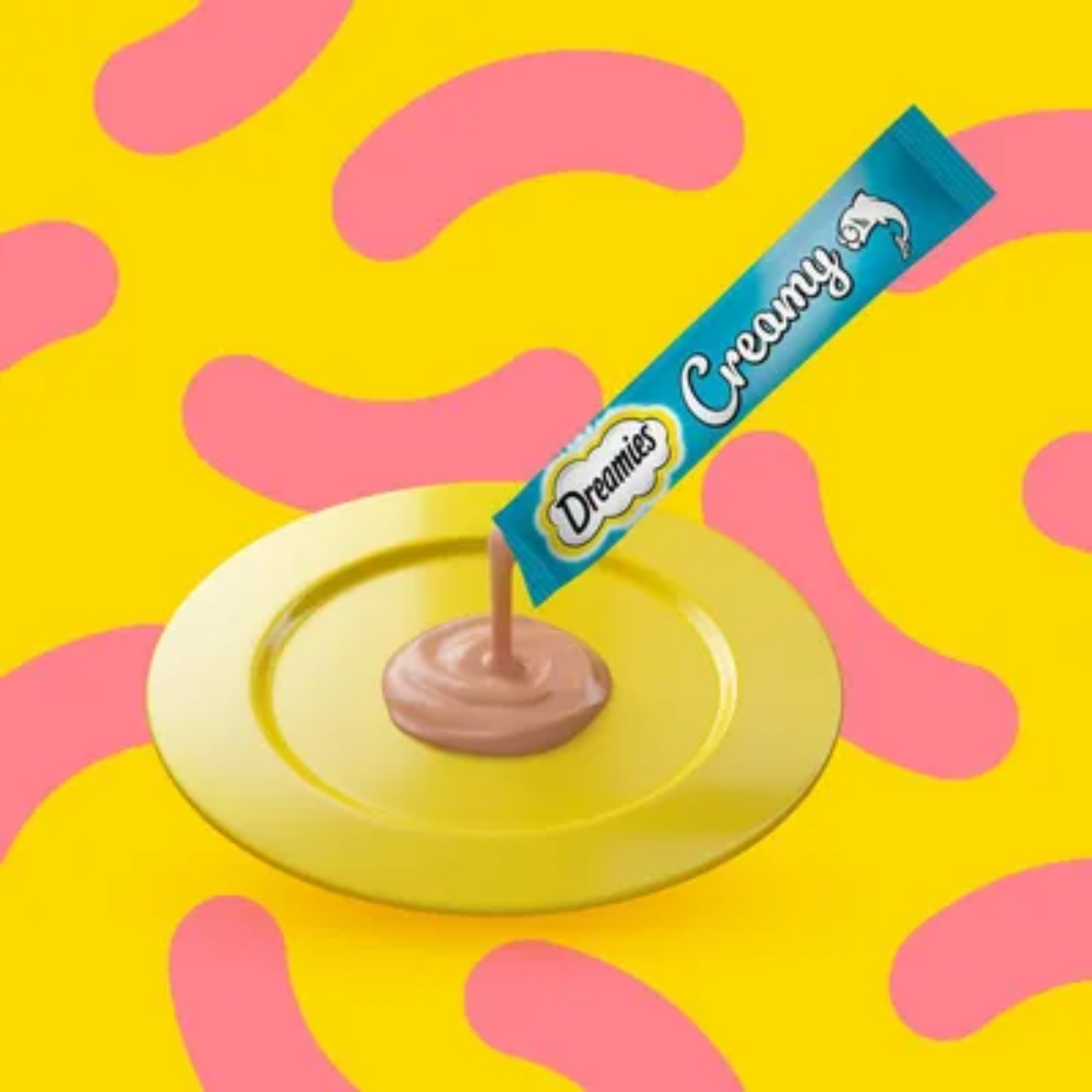 Dreamy's creamy chocolate bar being unwrapped on a yellow plate with a colorful abstract background