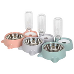 Set of pet bowls in pink, gray, and green with glass water bottles on a white background