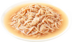 Plated dish of cooked noodles in a light broth on a white background