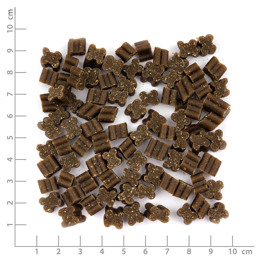 Pile of brown dog treats on a white background with measurement scale