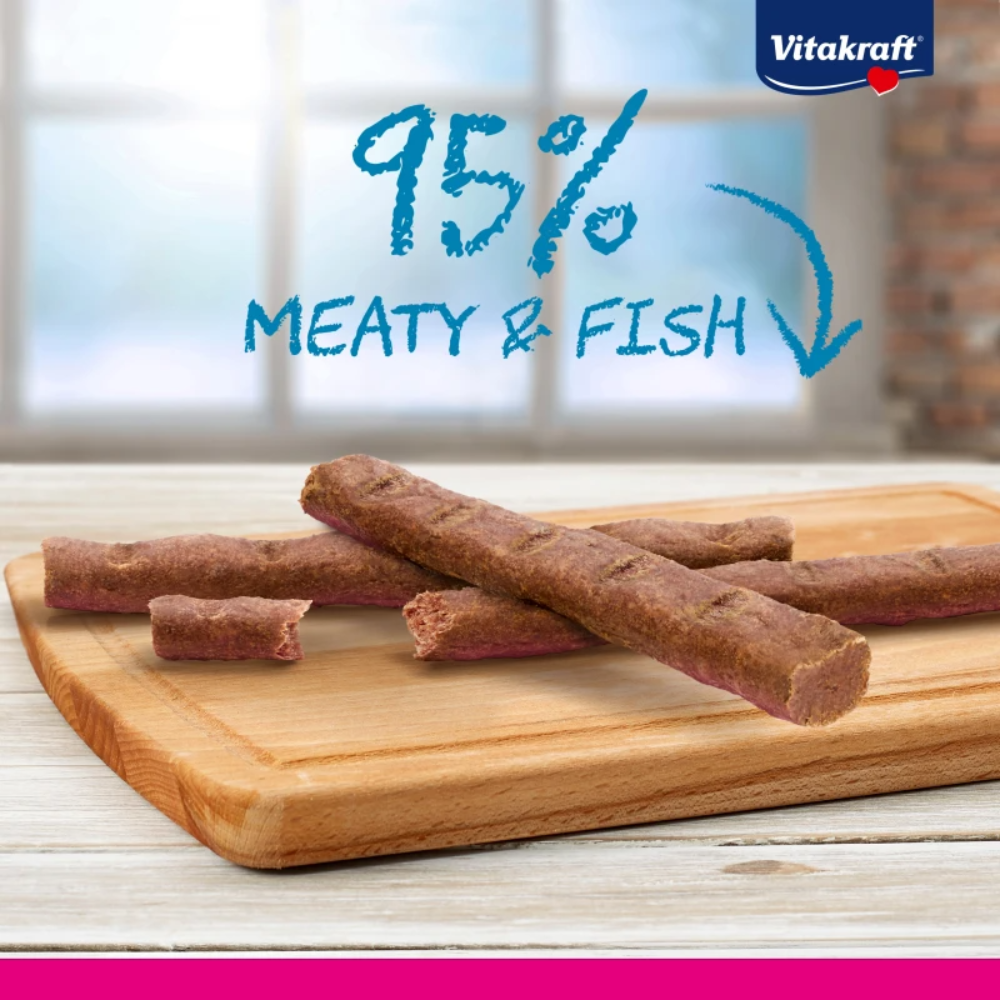 Dog treats on a wooden board with Vitakraft branding and text about meat content.