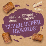 Dog treats with a purple speech bubble on a brown background, featuring text about 'real duck + proper crunch = Super Duper Rewards'.