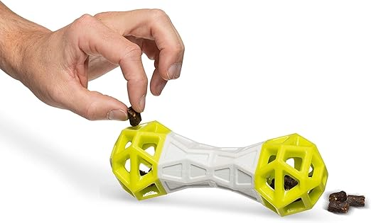 Dog chew toy with a hand placing treats inside on a white background
