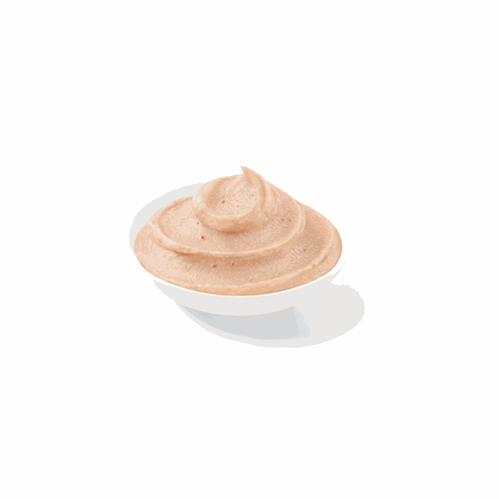 White bowl with a swirl of beige cream on a white background