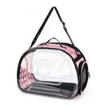 Clear pet carrier with pink interior and black straps on a white background