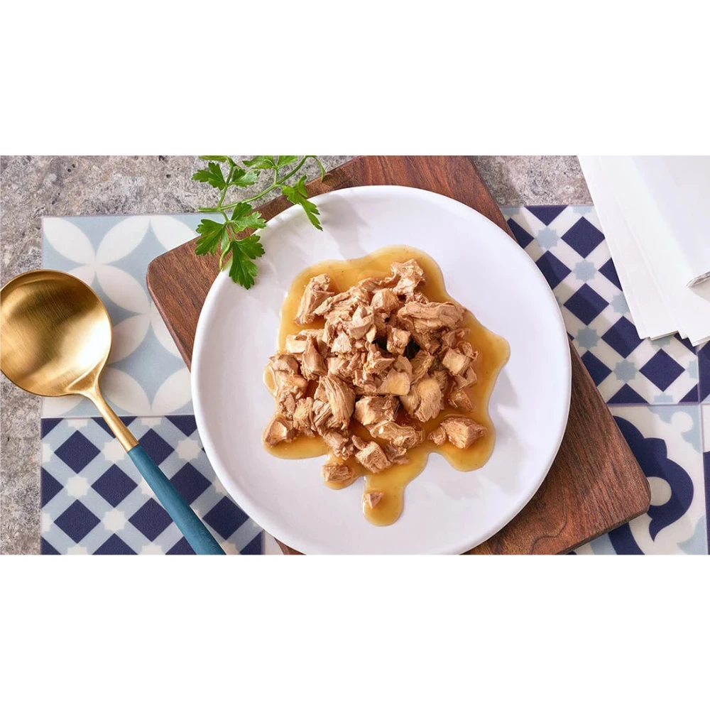 Plated dish of food with a gold spoon on a patterned tablecloth