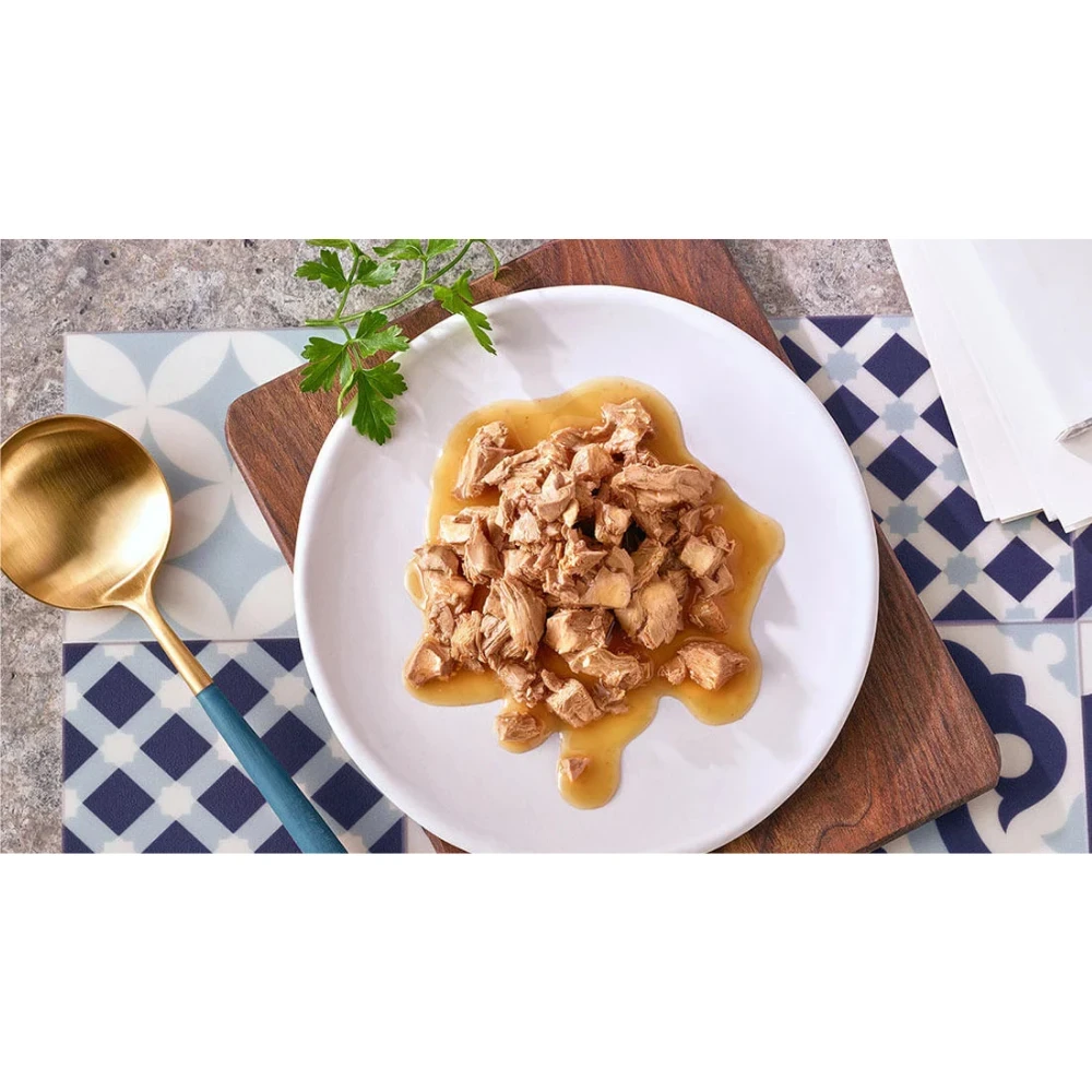Plated dish of food with a gold spoon on a patterned tablecloth