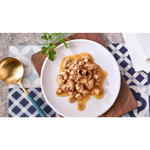 Plated dish of food with a gold spoon on a patterned tablecloth