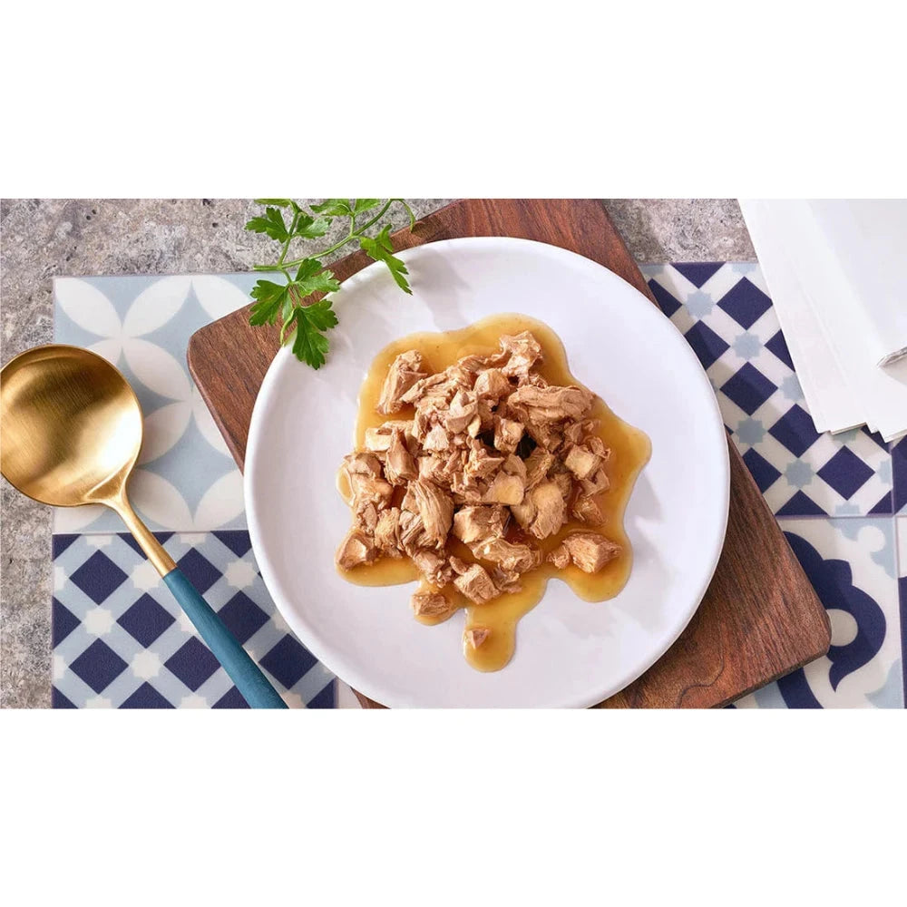 Plated dish of food with a gold spoon on a patterned tablecloth