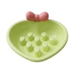 Green bowl with a pink bow and white cubes on a white background