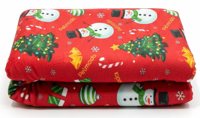 Folded red blanket with Christmas-themed pattern on a white background