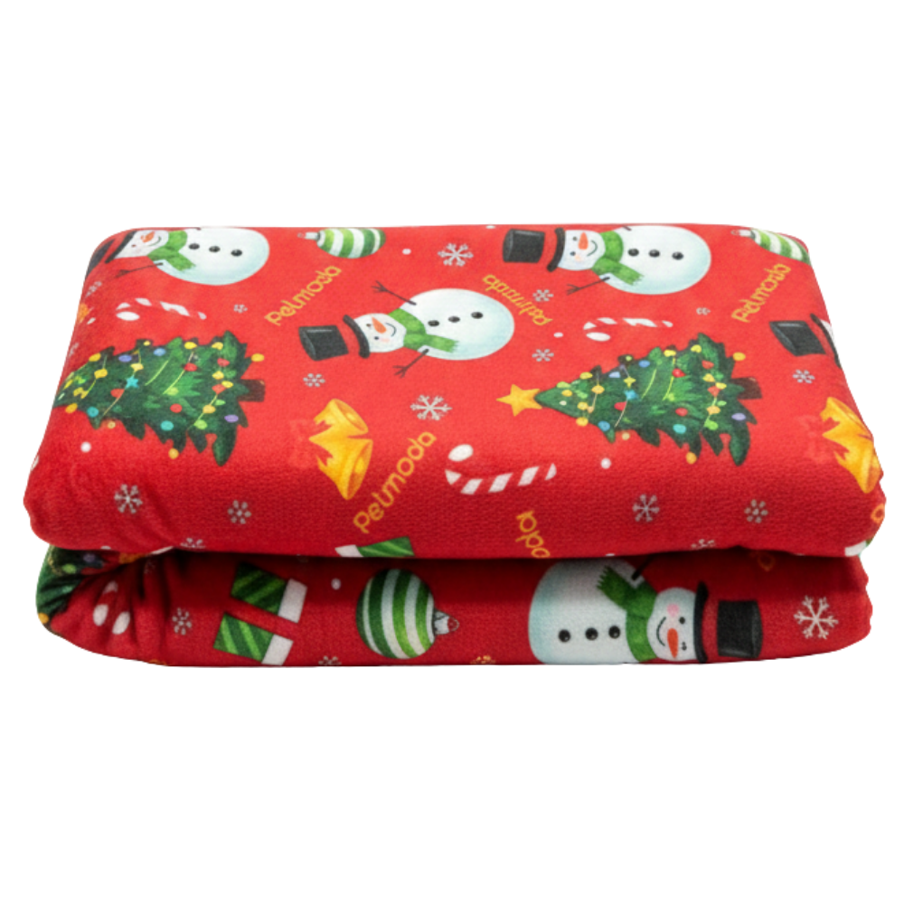 Folded red blanket with Christmas-themed pattern on a white background
