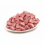 Heart-shaped raw meat pieces on a white plate with a white background