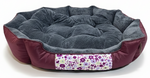 Round pet bed with floral patterned strip on a white background
