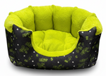 Pet bed with green interior and black exterior with white patterns on a white background
