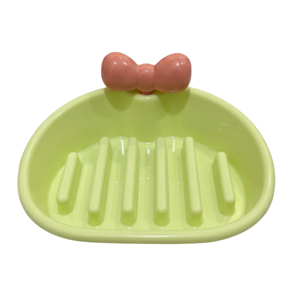 Green soap dish with a pink bow on a white background