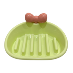 Green soap dish with a pink bow on a white background