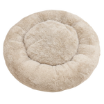 Round beige pet bed on a white background