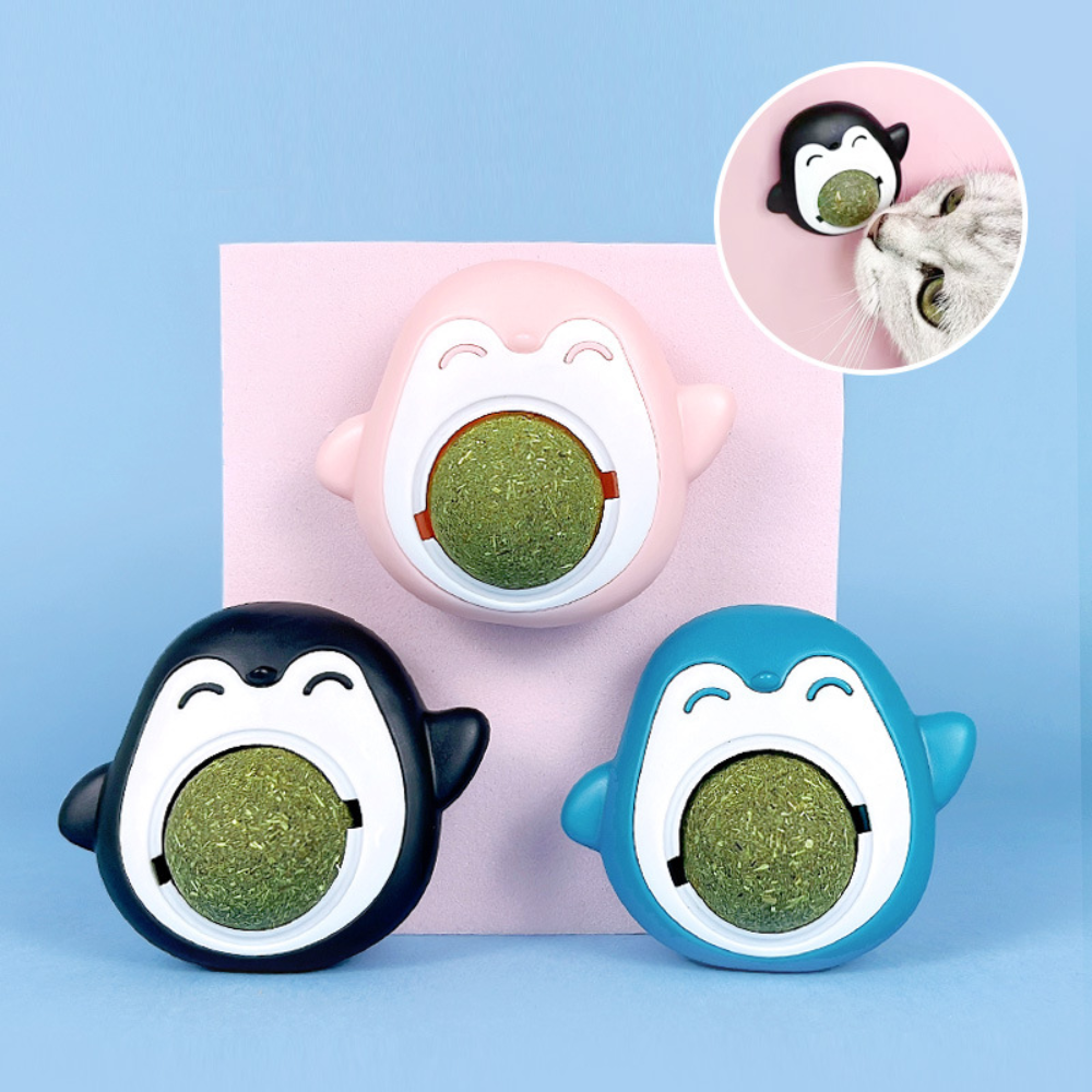 Three cartoon penguin-shaped pet toys with green treats inside on a light blue background.