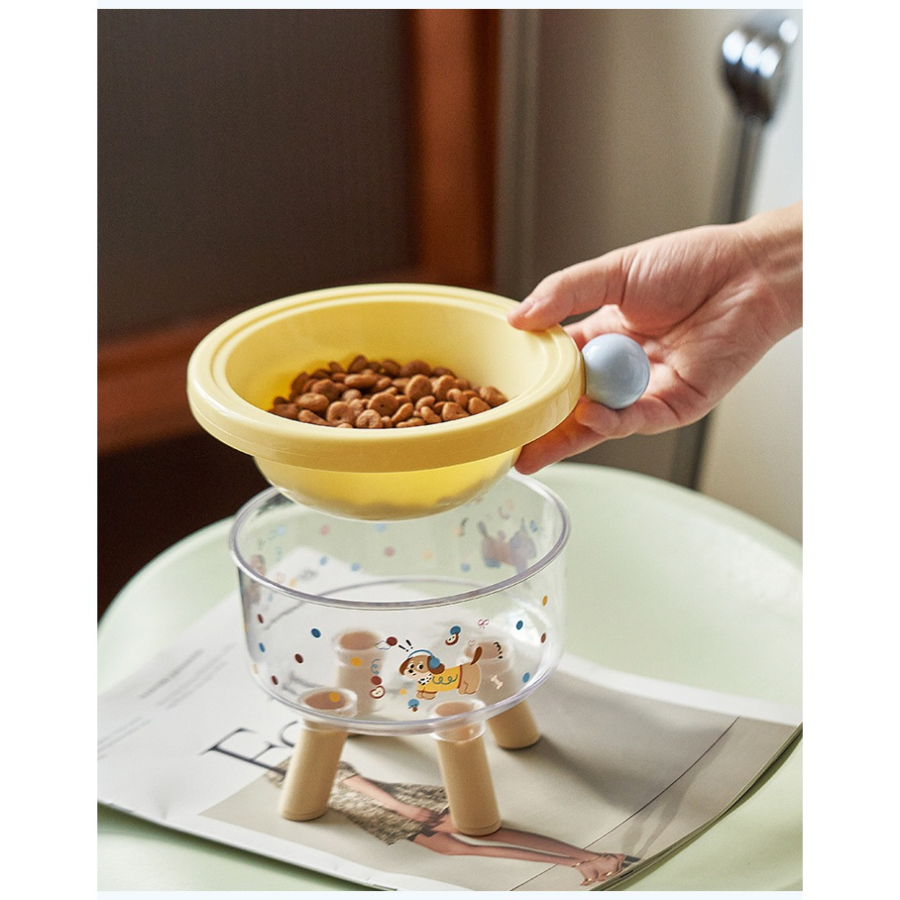 Yellow pet food scoop with a transparent stand on a table.