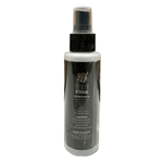 Spray bottle with black and white label on a tiled floor with wooden wall background