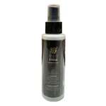 Spray bottle with black and white label on a tiled floor with wooden wall background