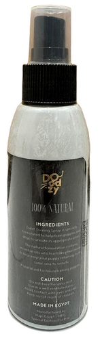 Spray bottle labeled 'Body Naturals' on a tiled floor with wooden wall background