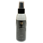 Spray bottle labeled 'Body Naturals' on a tiled floor with wooden wall background