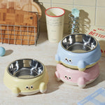 Two cute pet bowls in yellow and pink on a kitchen counter.