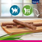 Dog treats on a wooden board with Vitakraft logo in the background