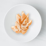 Raw chicken breast on a white plate with a light gray background