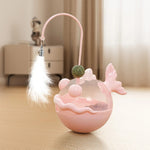 Pink pet toy with a ball and feather on a wooden floor
