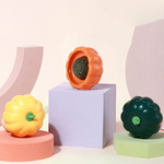 Colorful gourd-shaped objects on geometric platforms against a light pink background