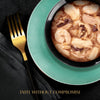 Bowl of soup with shrimp on a green plate with a gold fork, on a black background.
