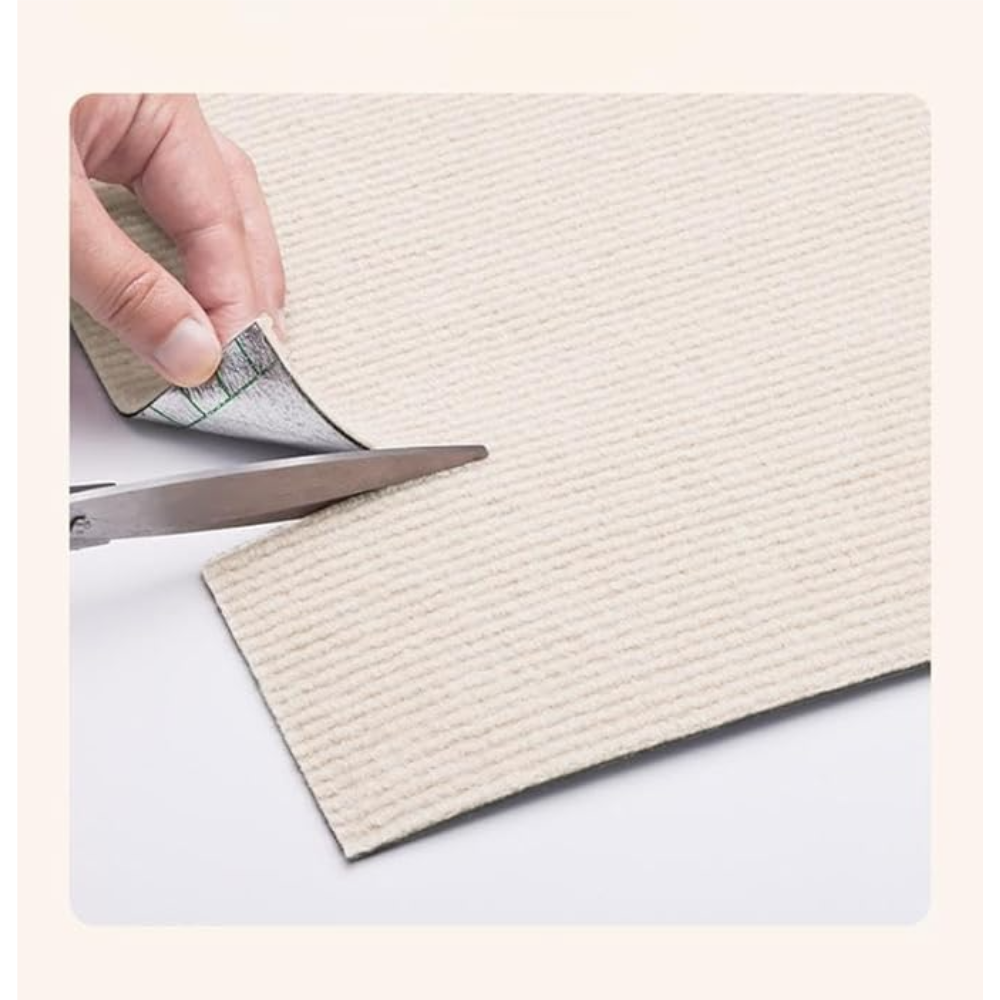 Person cutting a piece of textured beige paper with scissors on a white background