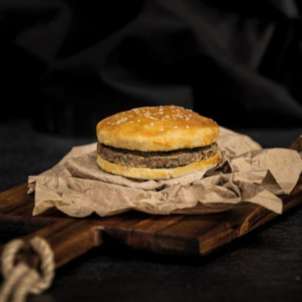 Burger on a wooden cutting board with a dark background