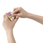 Person opening a small container with a colorful label on a white background