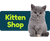 Gray kitten sitting next to a blue banner with 'Kitten Shop' text on a white background
