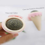 Close-up of a spherical object with a pink rim, held by a hand, on a light background.