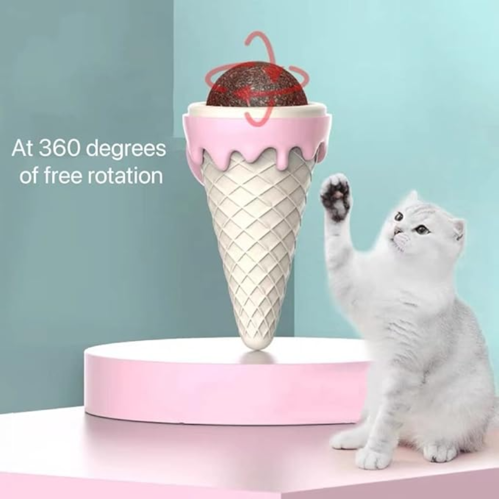 Cat playing with an ice cream cone-shaped toy that rotates 360 degrees on a pink platform.