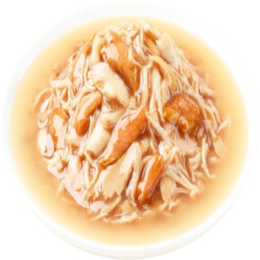 Delicate dish of noodles with meat and vegetables in a light broth on a white plate.